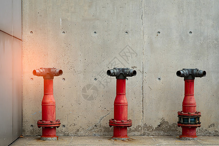 混凝土建筑水泥地板上的三个消防安全泵管道民众工具危险救援安装灭火器情况喷嘴阀门图片