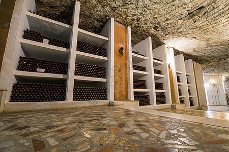 葡萄酒厂的酒瓶储存洞穴仓库文化地窖店铺藤蔓材料酒精石头葡萄园背景