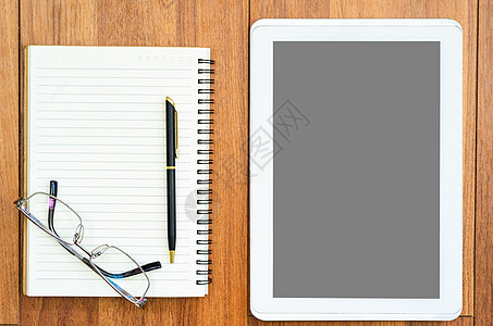数字平板电脑用眼镜和木甲上注纸制成小样办公室书样机文档教育奶制品桌子日记职场记事本图片