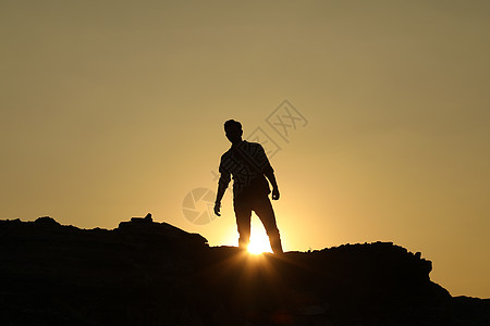 山上人的剪影爬坡阳光岩石冒险自然光晴天阴影男性地点男人图片