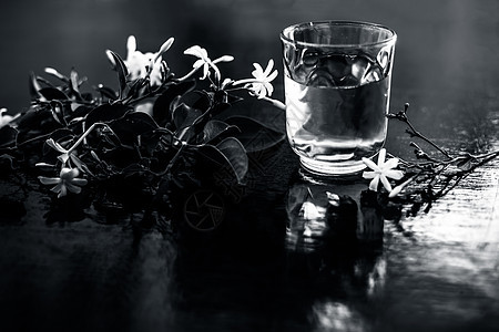 印度茉莉花或Juhi或在木质表面用透明玻璃和鲜花提取的甘油草本植物瓶子叶子茉莉香味香气植物植物学三叶草治疗图片