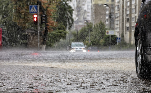 路城市路面和人行道的水车站在十字路口 有暴雨背景