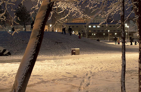 孩子们在公园里漫步 在下雪后带清雪城市降雪季节魔法场景操场灯笼天气景观假期图片