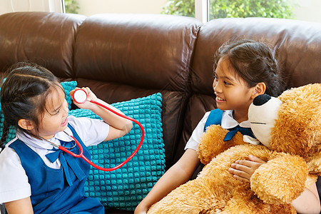 两个小女孩笑着 和医生玩听诊器玩具职业卫生童年保健病人婴儿女性治疗儿科图片