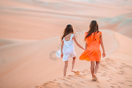 阿联酋大沙漠沙丘中女童生态滚动阳光女孩乐趣假期环境干旱栖息地孩子图片