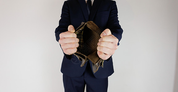 一个身着商业西装的男人 手里拿着一个空钱包金融危机失败股票友谊贫困企业荒野工作损失破产图片