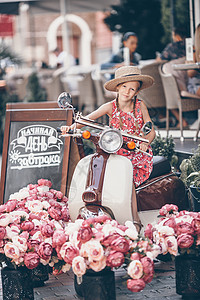 穿着帽子的可爱小女孩 在脚踏车室露天街道起动机驾驶摩托车旅行假期孩子快乐享受发动机图片
