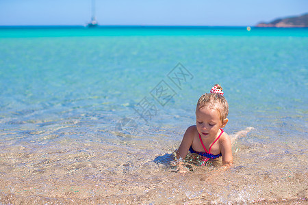 可爱的小女孩在热带海滩浅水区玩得开心旅行童年支撑孩子草帽旅游婴儿情调海岸线海洋图片