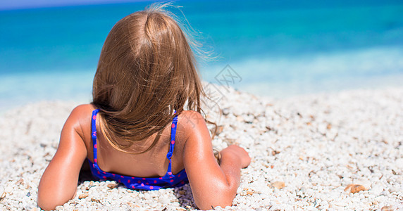 热带度假期间玩得开心的可爱小姑娘女士海滩乐趣旅行海岸线婴儿童年孩子假期太阳图片