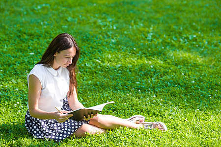 在公园外面看书的年轻女子图片