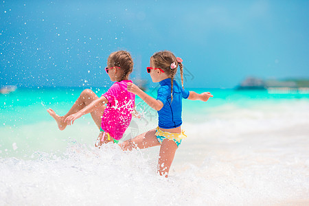 女孩暑假期间在热带海滩玩得开心 在浅水一起玩耍的小女孩们女性孩子海岸海岸线乐趣情感享受女儿情调姐姐图片