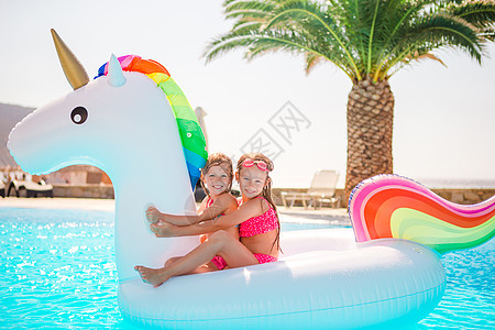 两个小孩在游泳池里玩耍呢太阳镜享受假期幸福游泳衣姐姐太阳女孩孩子青年图片