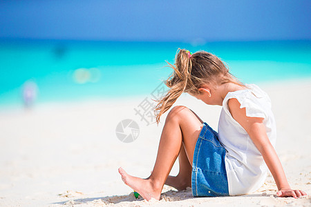 沙滩小女孩暑假期间海滩上可爱的小女孩在沙滩上闲暇童年享受晴天海岸海景女儿幸福假期支撑背景