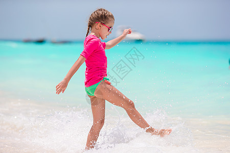 沙滩度假时可爱的小女孩 在浅水中玩得开心蓝色闲暇海洋晴天快乐天堂幸福支撑情调女孩图片
