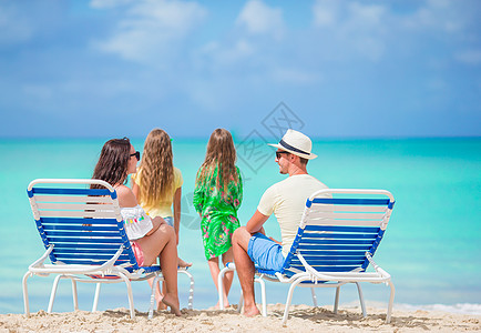 暑假期间在海滩上快乐的家庭日光妈妈女儿爸爸海岸男人躺椅海滨享受女孩图片