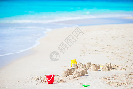 白色热带沙滩的沙堡和塑料小孩玩具女孩海滨旅行支撑建筑乐趣游戏孩子房子情调图片