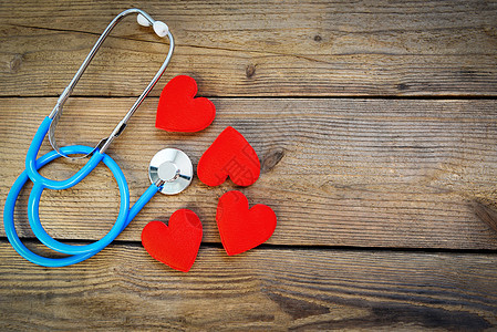 心脏健康和红心 木制背景有听诊器图片