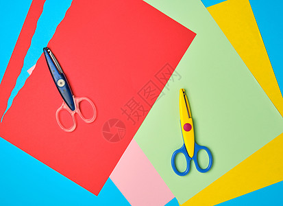 一对塑料剪刀和彩色剪切图纸的彩皮纸孩子办公室边缘卡通片幼儿园刀刃工具学校玩具金属图片
