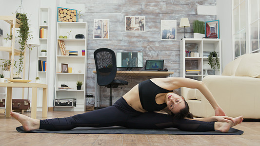 柔软的年轻女子站在瑜伽垫上平衡女性活动运动装灵活性女孩女士瑜伽训练运动图片