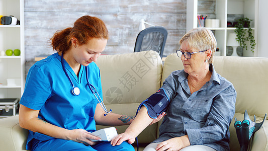 接受高级妇女血压的女医生测试工作照顾者药品心血管病人帮助护理考试护士背景图片