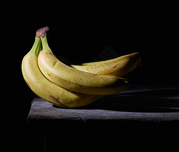 一堆黄黄色的无皮熟香蕉桌子小吃热带食物黑色饮食甜点木板水果图片