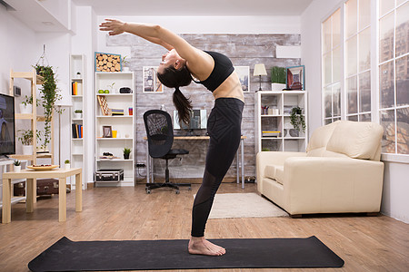 青年瑜伽执业者站立后伸展房间女性运动装力量活动从业者女士姿势练习身体图片