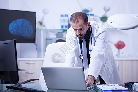 医生在他的笔记本电脑上工作 检查其P的治疗情况图片