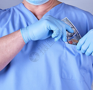 男医生在他的衬衫口袋里放了一瓦美金薪水工资账单外科医师货币现金金融从业者手术图片