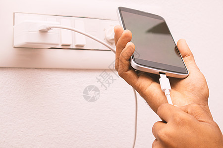2020 年 1 月 18 日 印度马斯基 — 手持智能手机并将 USB C 型充电器电缆连接到手机进行充电图片