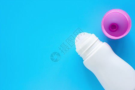 女性除臭剂或以蓝底粉红色封面的瓶子滚动图片