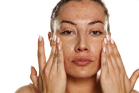 年轻女子用手指在眼睛下施戴隐蔽器女士化妆品校正器肤色女性液体皮肤雀斑奶油护理图片