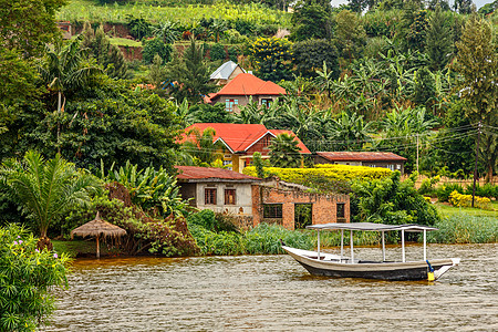 屋顶船停在海岸 后面有伦丹村的Rwandan村小屋丛林丘陵支撑日光房子村庄运输植物热带图片