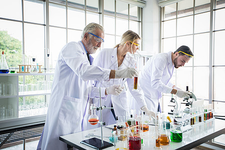 医学研究和科学家们正在用显微镜进行工作男性研究员烧杯团队学习职业化学家外套测试生物学图片