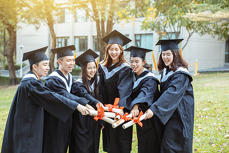 在大学校园持有文凭的毕业礼服中快乐学生人数百分比仪式多样性朋友成就女士证书教育友谊男人团体图片