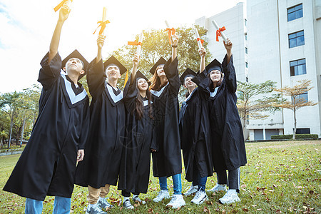 在大学校园持有文凭的毕业礼服中快乐学生人数百分比女士庆典微笑学士多样性仪式成就学校朋友同学图片