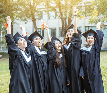 在大学校园持有文凭的毕业礼服中快乐学生人数百分比朋友仪式男人微笑团体多样性同学友谊证书长袍图片