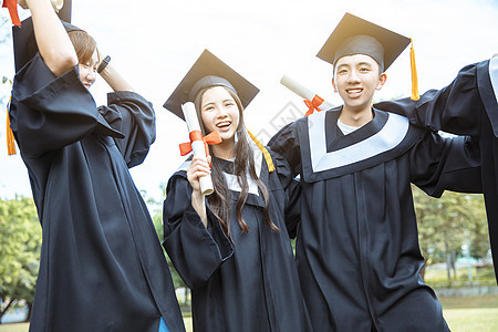 在大学校园持有文凭的毕业礼服中快乐学生人数百分比庆典同学团体女孩女士微笑友谊仪式乐趣男人图片