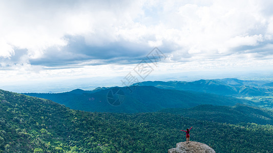 年轻女人喜欢从山顶看山谷景色天空闲暇旅行女士悬崖顶峰运动太阳男性农村图片