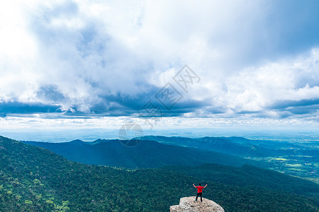 年轻人喜欢从山顶看山谷景色公园男人悬崖岩石阳光耐力太阳天空登山者自由图片