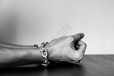 紧紧的雄性手与铁链在桌子上危险安全惩罚禁令压力休息囚犯金属监狱奴隶图片