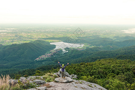 年轻人喜欢从山顶看山谷景色阳光男性运动公园冒险登山者悬崖旅游地平线男人图片
