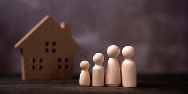 木制人物家庭站在一座木屋前 保护和安全家庭安全财产保险和房屋的概念图片
