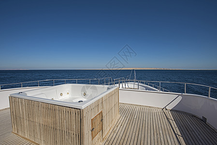 在大马游艇和热水浴缸上面的船首上观光柚木地平线海景假期蓝色旅行奢华栏杆热带甲板图片