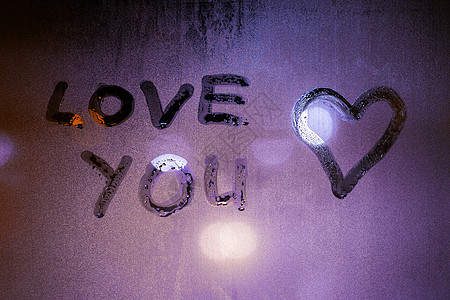 雾夜窗玻璃上手写的“爱你”和心形符号图片