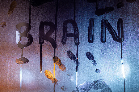 大脑字词写在夜湿窗口玻璃上 有棕榈指纹 贴近背景模糊图片
