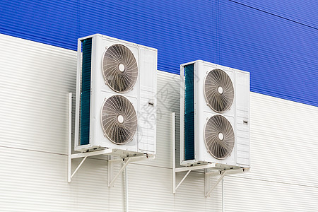 在蓝色和白色金属工业墙壁上两台双压缩空调机冷凝器图片