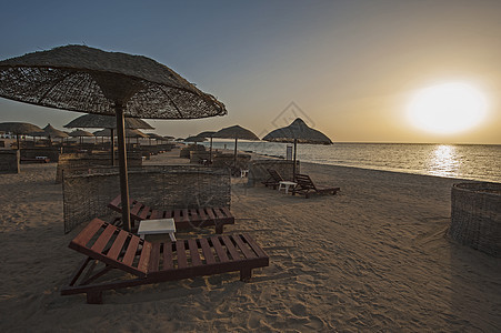 热带度假胜地海滩的海洋上升起假期日光桌子太阳椅旅行沿海地平线黄色闲暇海岸线图片