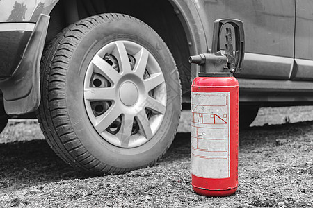一辆灭火器站在汽车附近的地面上 作为防火剂 (b) 预防道路火灾图片