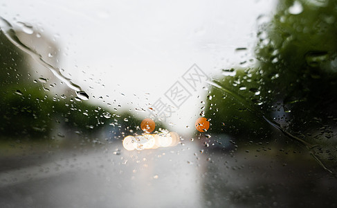 雨滴在挡风玻璃上 背景的夜晚城市灯光模糊不清窗户旅行下雨摄影天气液体蓝色交通风暴街道图片