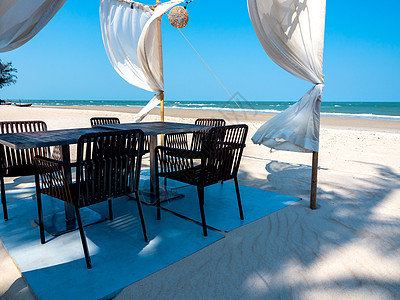 白色桌子上沙滩上的浪漫餐桌海滩庆典蓝色旅行餐厅奢华热带织物环境支撑背景